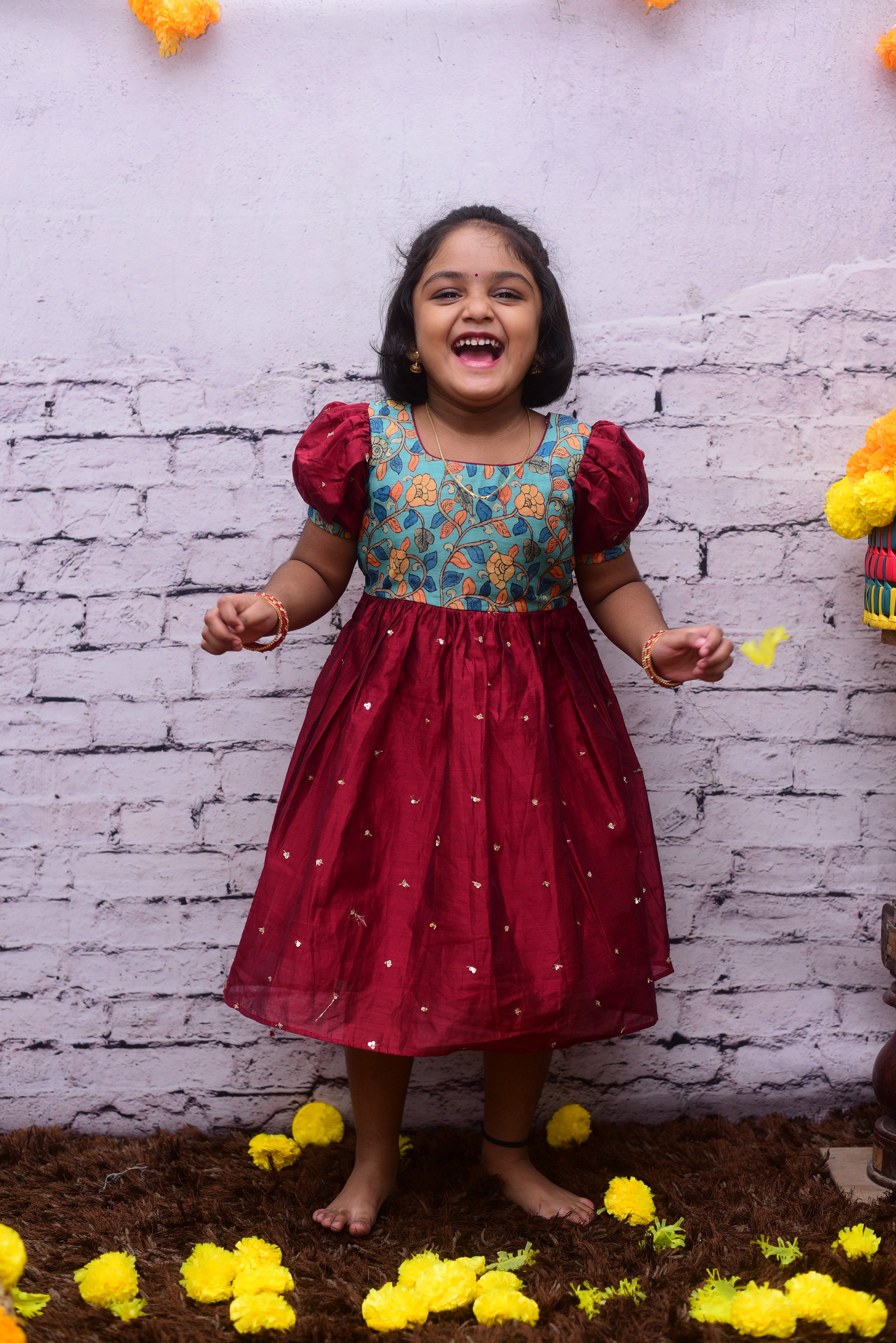 Get your teenage girl the perfect party wear dress! This beautiful sequin red dress is embellished with Kalamkari yoke and puff sleeves and is perfect for the special occasion.