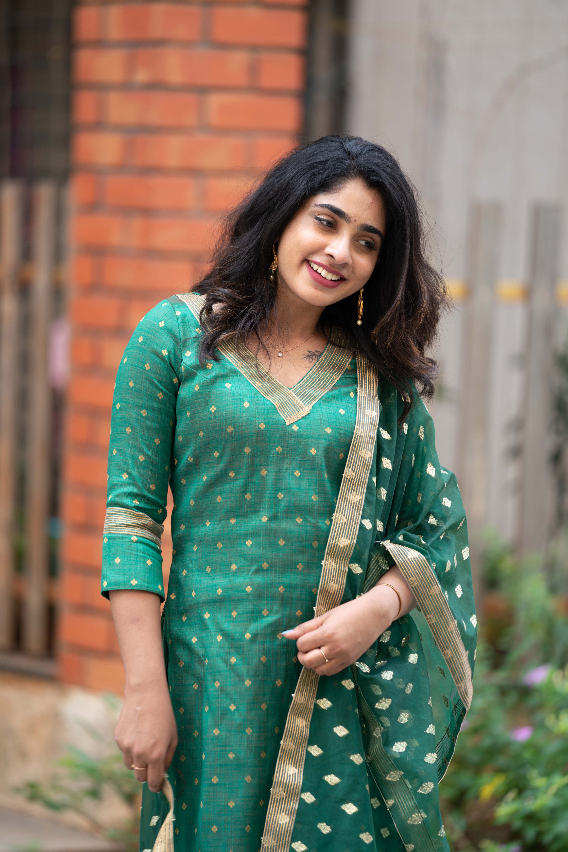 Shop this stylish green kurti for women, deep v neck straight kurti in raw silk with zari embroidery and lace detailing. Comes with a matching organza dupatta.