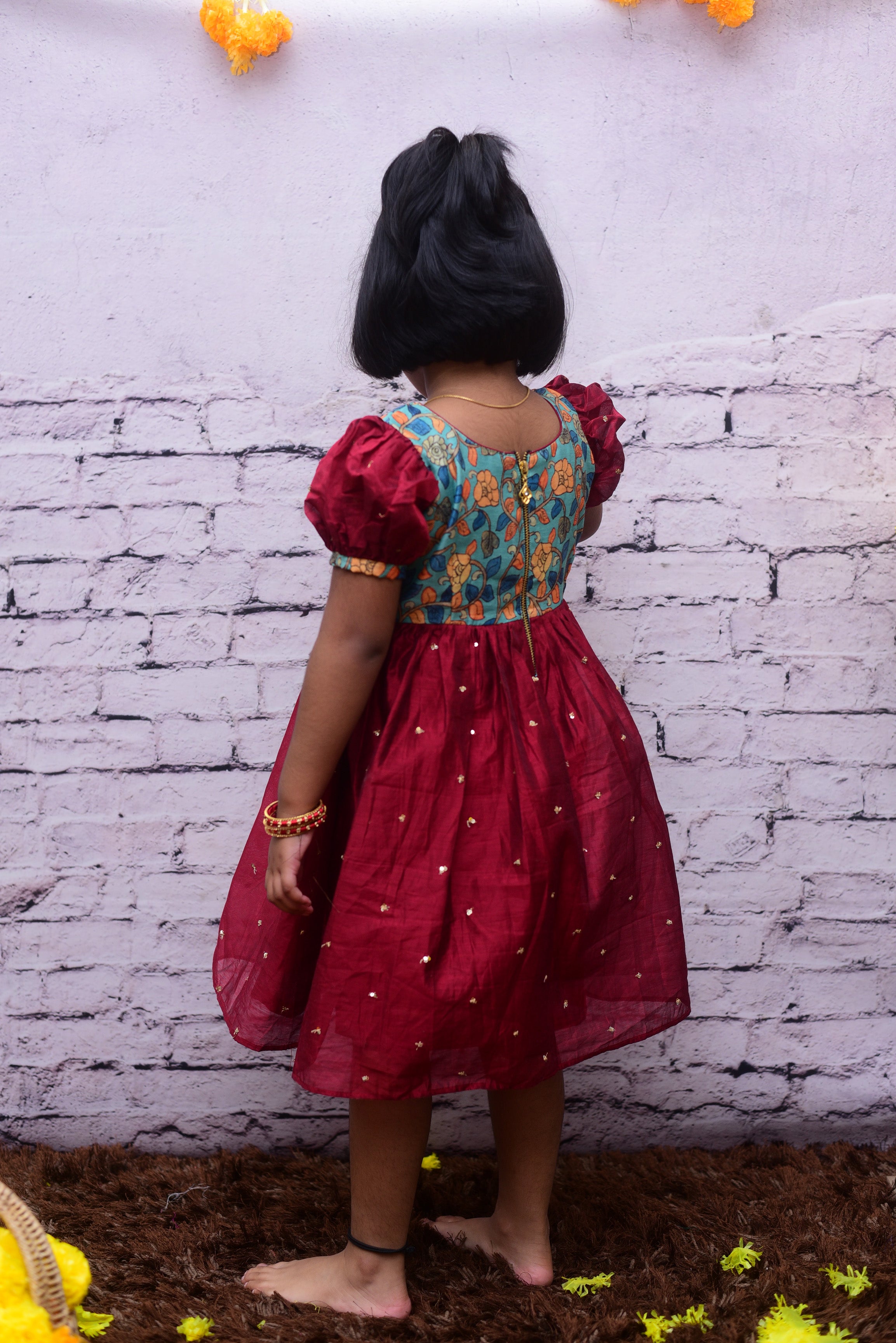 Find the perfect designer dress for your teenager with our range of beautiful sequin short frock with kalamkari yoke and puff sleeve. Perfect for parties and special occasions.